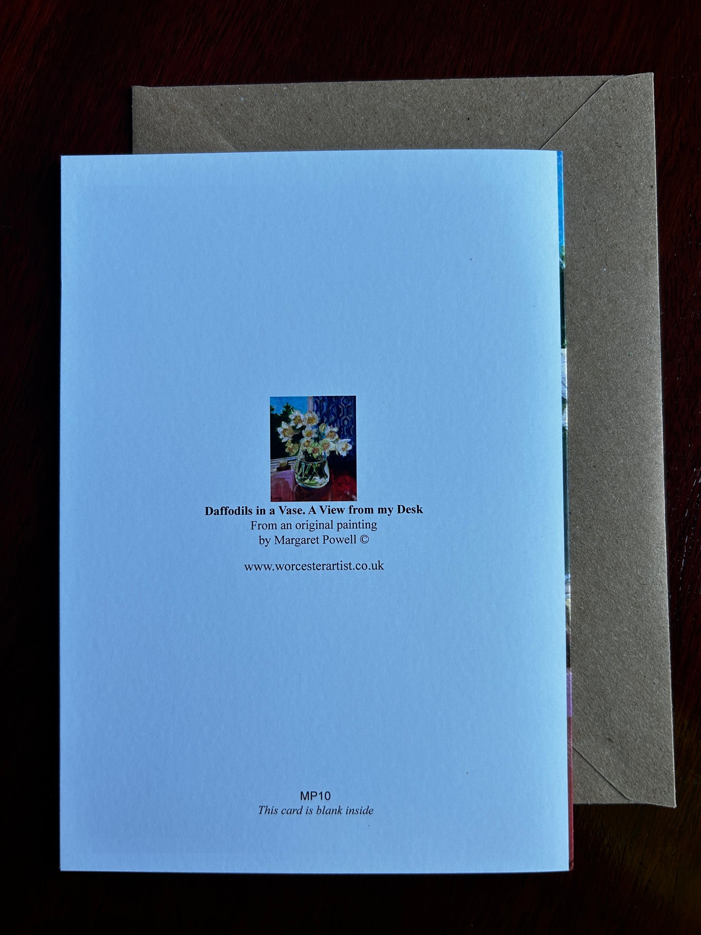 Reverse of greetings card of daffodils in a glass vase. Displayed with brown envelope.