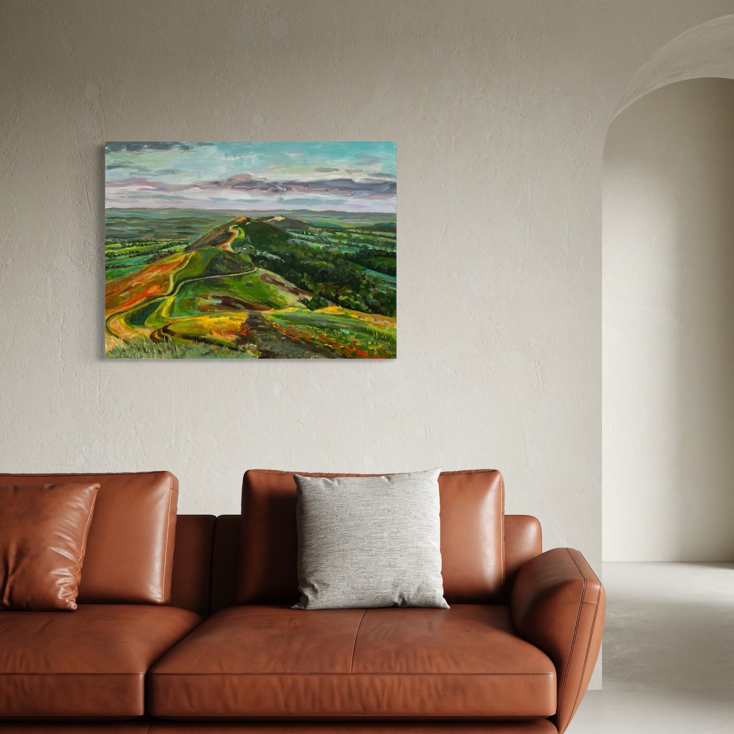 An extra large original painting of the Malvern Hills, Morven Hill Symphony by Worcester artist Margaret Powell, shown here in the room setting above a large leather sofa.