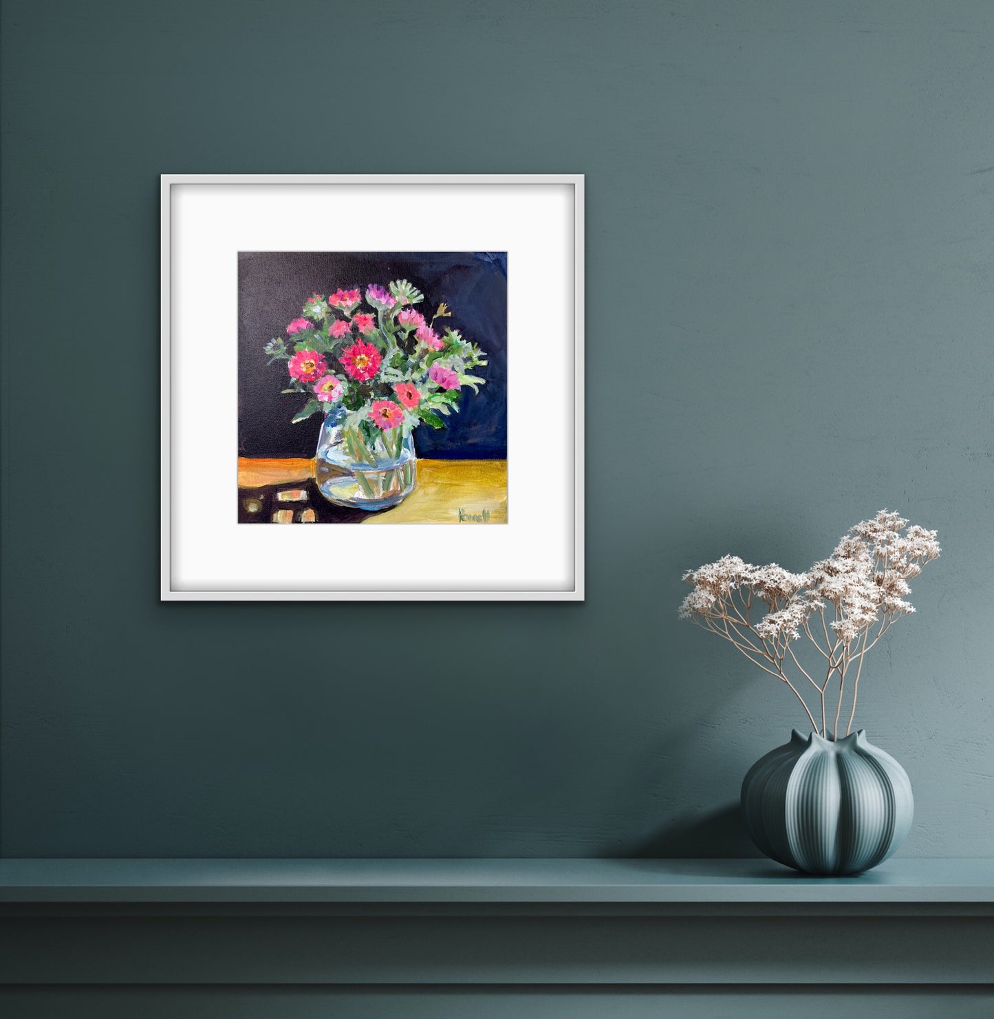 Print of asters in a vase displayed in a white frame and mount on a grey wall.