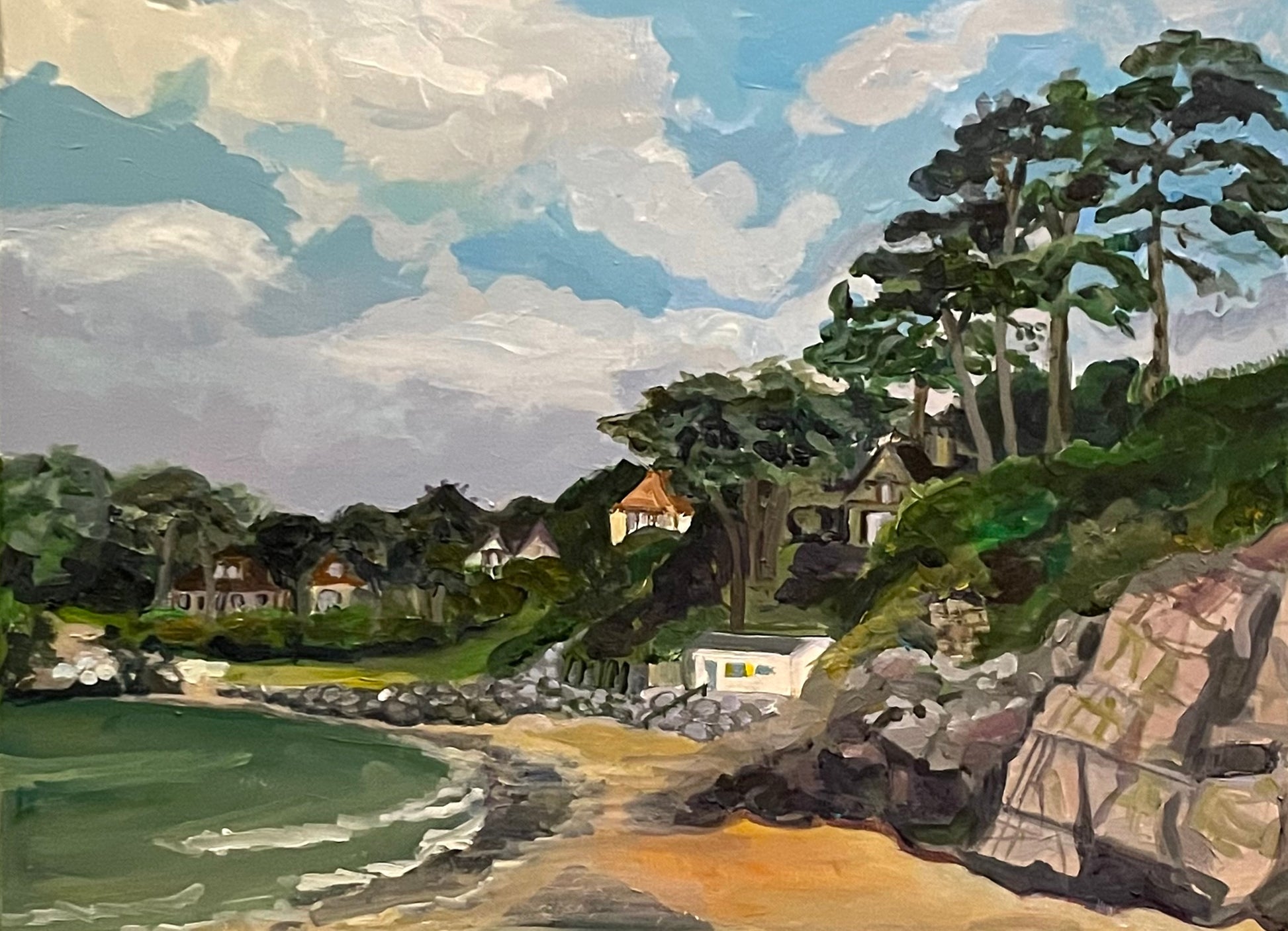 Painting of Caswell Bay in the Gower, Wales with white clouds in a blue sky and rocks and sea in foreground with trees and houses on the headland.By Worcester Artist Margaret Powell. 