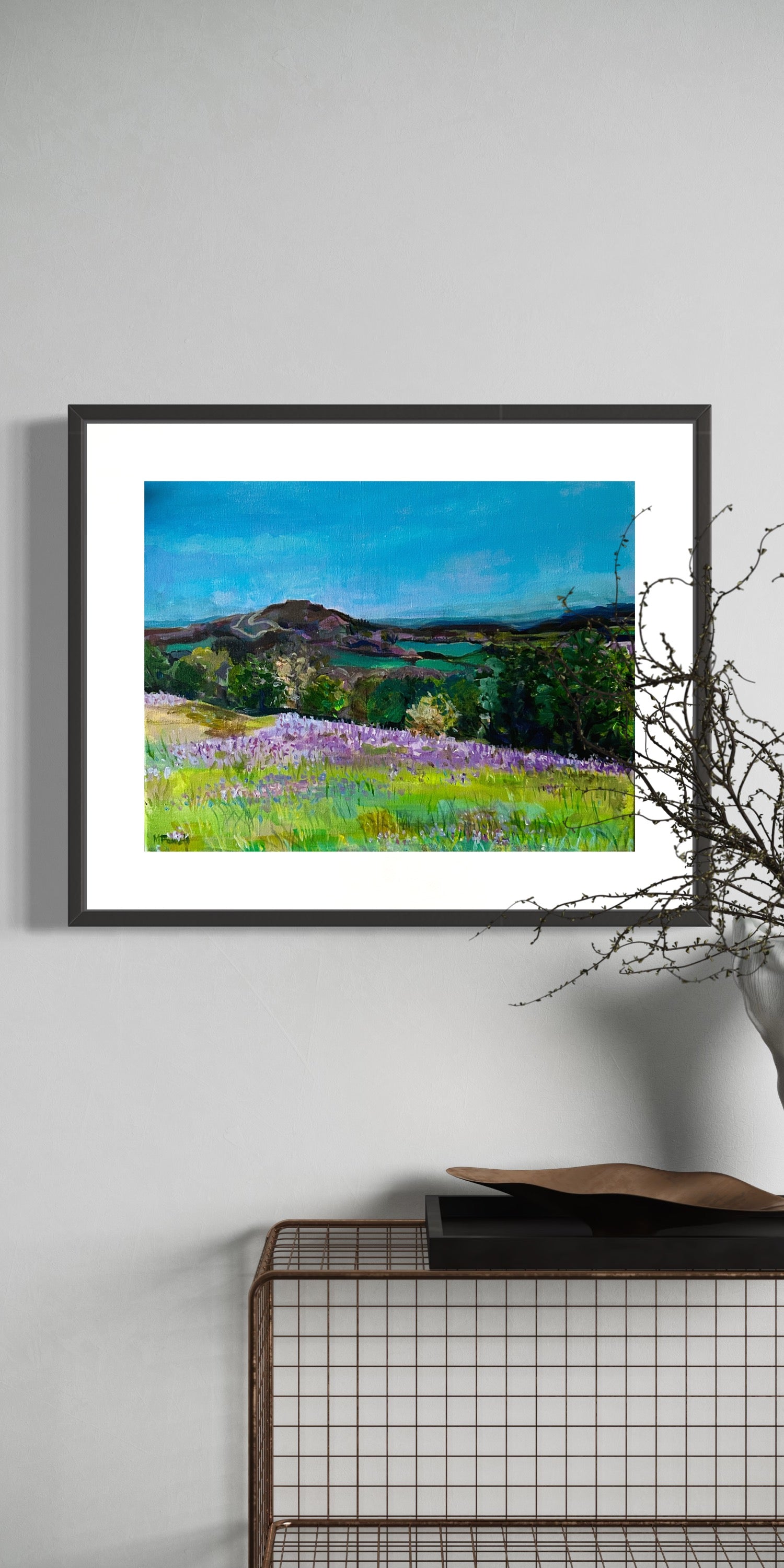 Framed print of Bluebells in the Malvern Hills from original painting by Margaret Powell. Displayed on a white wall.