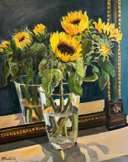 Print of a fine art painting of sunflowers displayed in a vase in front of a vintage mirror.