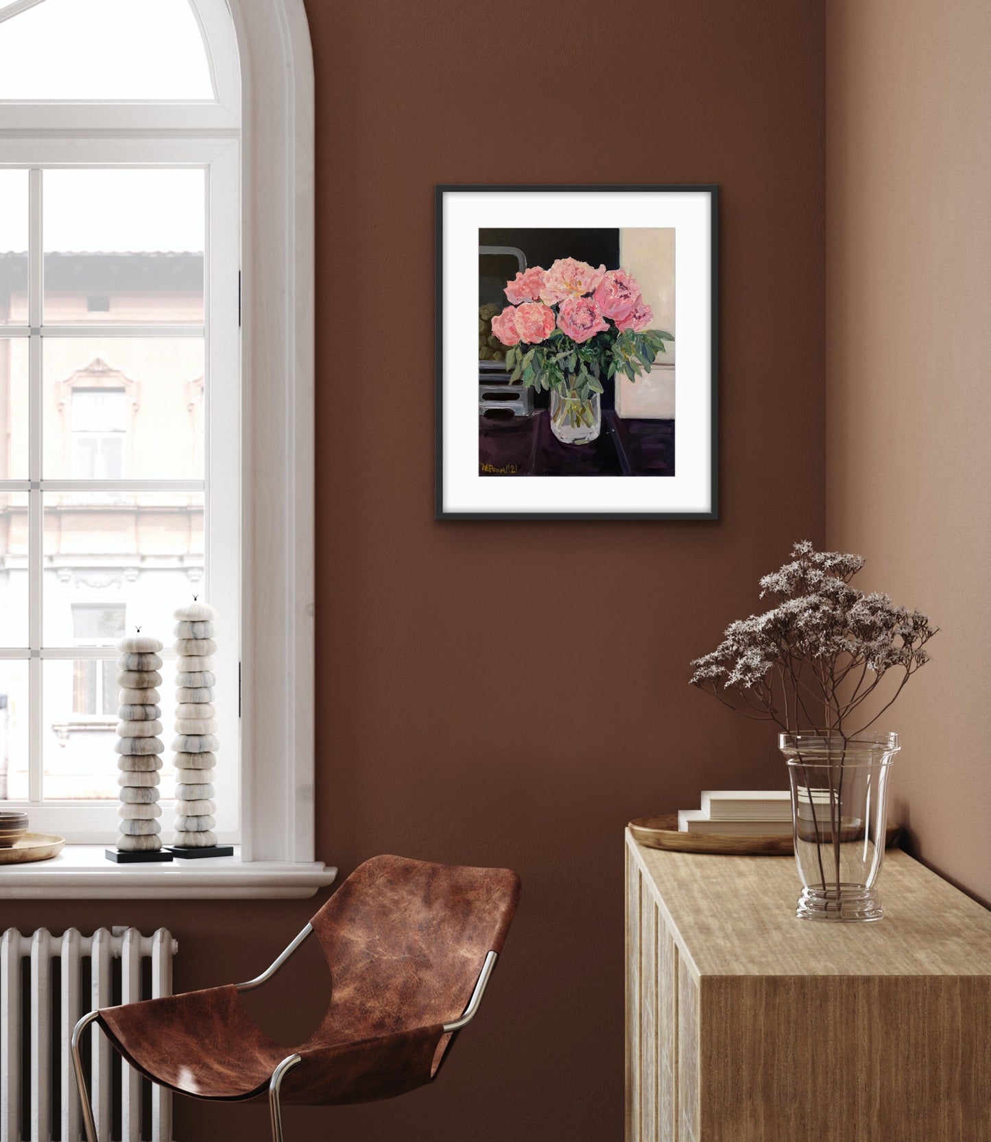 Original painting of Peonies on the Hearth by Margaret Powell, Worcester artist. Displayed in a black frame with white mount on a brown wall with furniture in foreground.