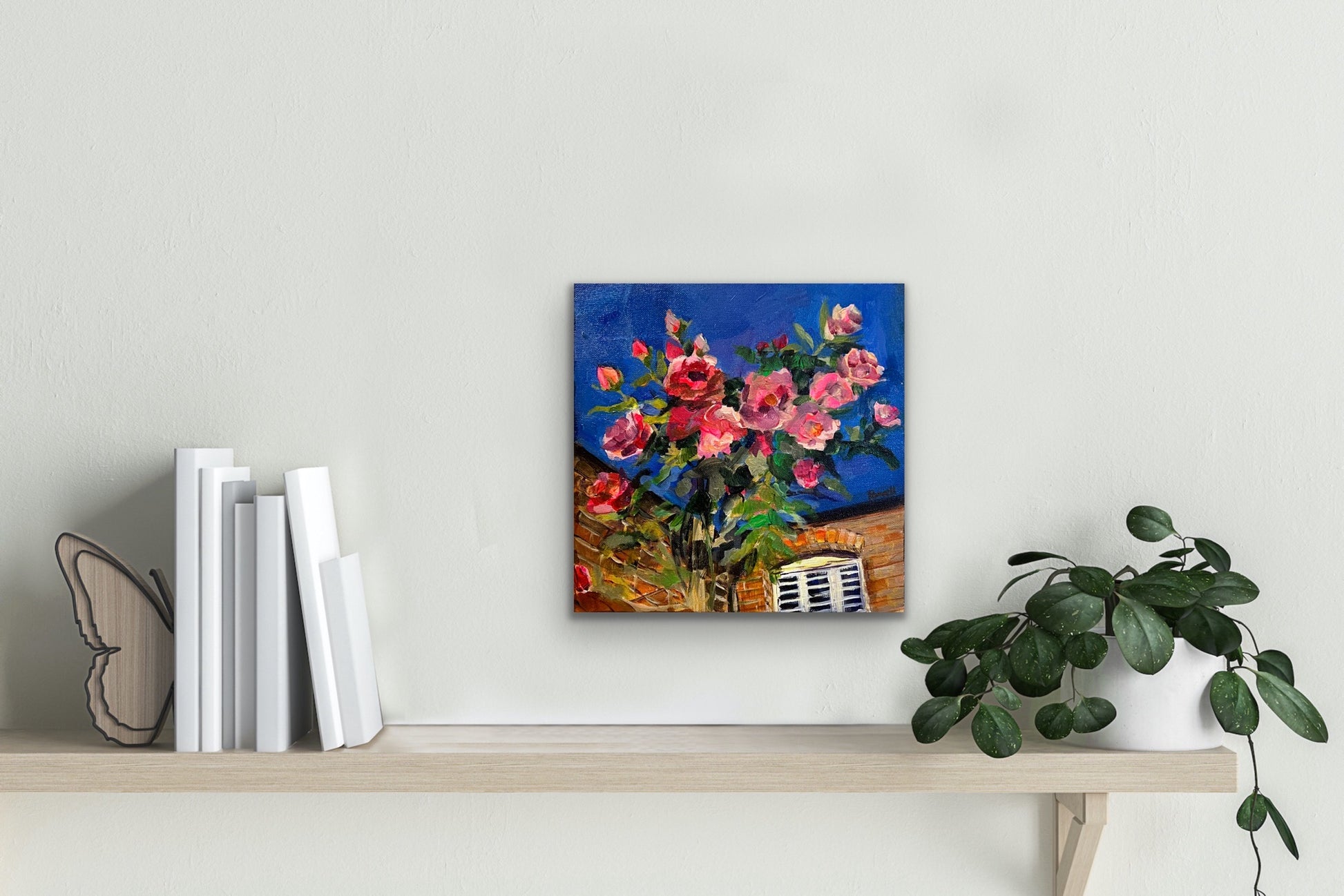 Original fine art painting by Worcester artist Margaret Powell entitled Debbie's Roses displayed against a white wall above a shelf